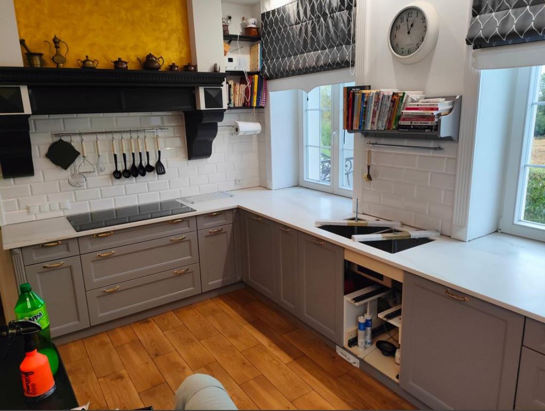 Küchenarbeitsplatte als ein L Stück aus hellem Konglomerat.